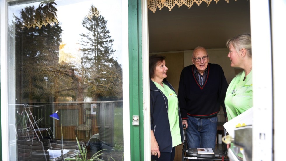 Hemtjänstbesöken är den enda fysiska samvaro Bertil Larsson, 95, har haft den senaste månaden. Anette Andersson och Cedda Cederlund försöker lätta upp tillvaron, bland annat med knepiga tankenötter.