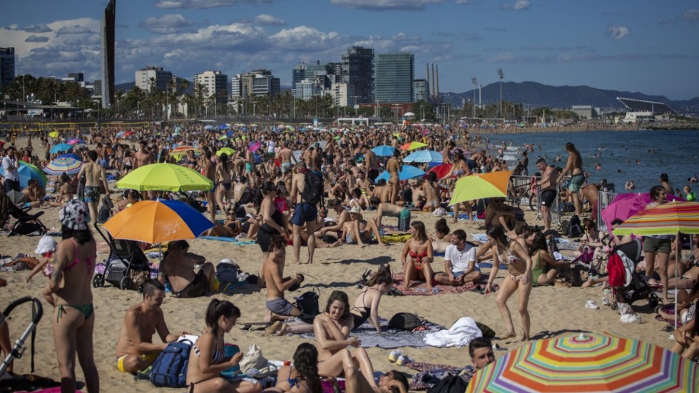 I Barcelona är stränderna redan fullpackade, men turistindustrin skriker efter gäster. Bild från i lördags.