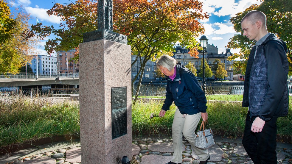 Kerstin Alm och Zachary Alm lägger blommor vid minnesmonumentet i Carl Johans park i Norrköping.