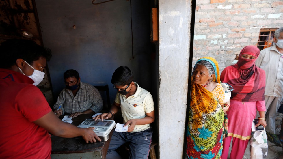 Fattiga indier i staden Prayagraj lämnar fingeravtryck för att hämta ut livsmedelsransoner på torsdagen. Indien är ett av flera länder som Världsbanken ska rikta ytterligare stöd till i virustider.