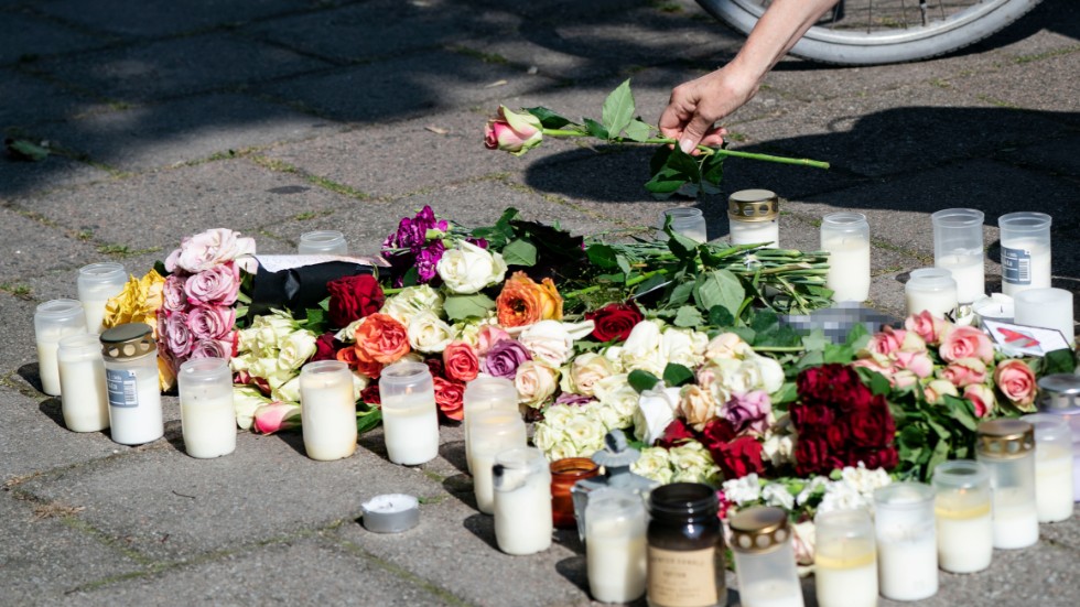 En kvinna lägger ner en ros vid minnesplatsen på Sergels väg i stadsdelen Ribersborg i Malmö där en 30-årig kvinna skjutits till döds föregående dag. Arkivbild.