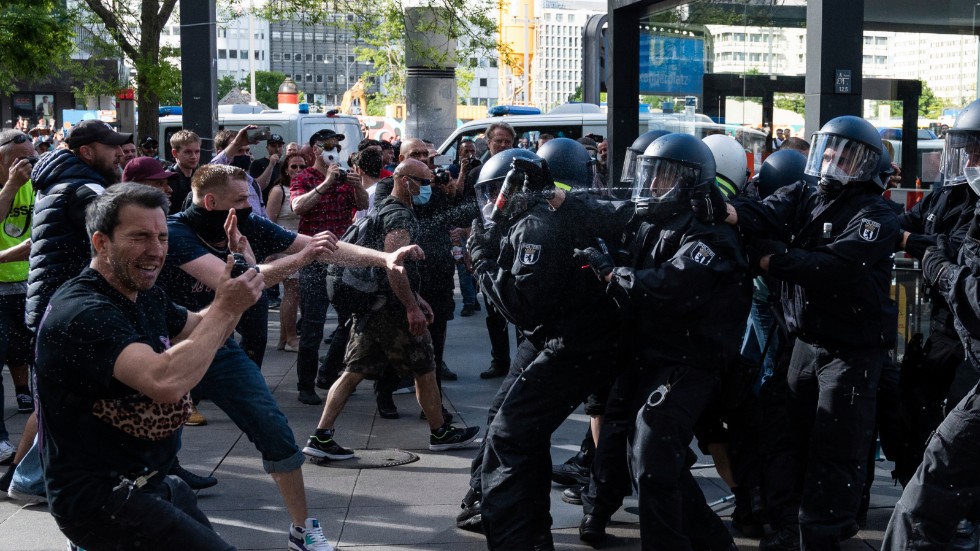 Polis använder sig av pepparsprej för att skingra demonstranter vid Alexanderplatz i Berlin den 9 maj.