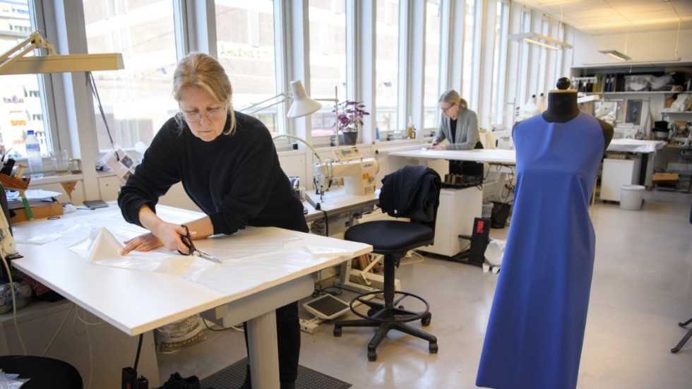 Anette Hovmark klipper i plast som ska användas till förkläden.