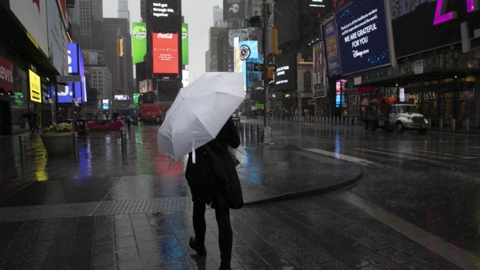 En kvinna går över ett tomt Times Square i centrala New York.