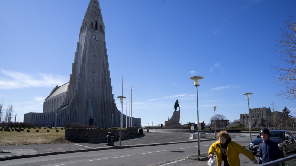 Två pojkar passerar ett tomt torg framför Hallgrímskirkja i Reykjavik i slutet av april, då landet meddelade lättnader i coronarestriktionerna.
