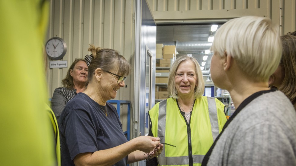 Carina Thomasson, IF Metall Gotland, visar Berit Müllerström (gul väst) små gummidelar som har producerats i fabriken. 