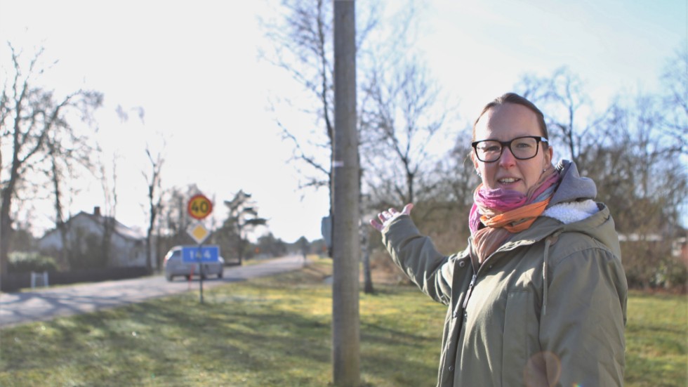 Maria Malm visar en av de få belysningsstolpar som finns kvar längs länsvägen genom Stånga. Intresseföreningen är irriterad över att regionen och Trafikverket aldrig kommer överens. Ingenting händer.