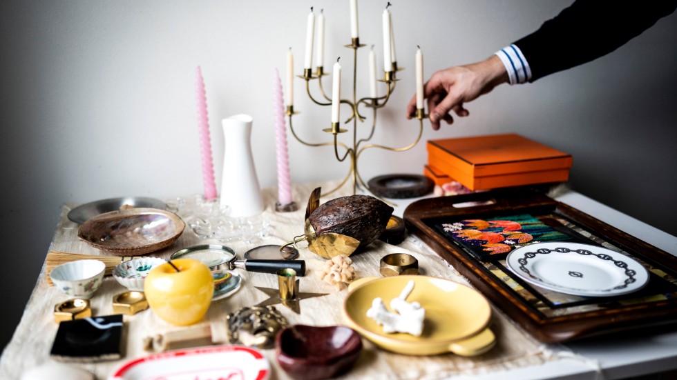Minnessaker blandas med loppisfynd. Ljusstaken modell 2454 av Josef Frank står på ett bord bredvid en bricka med motiv av fjärilsvingar, som Gustavs morfar, kapten i flottan, tog hem från en världsomsegling. På den ligger tavlan med tulpaner som broderades av Gustavs mamma i tonåren.