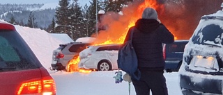 Två bilar i brand på parkering