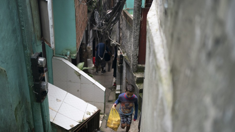 En pojke på väg upp genom en gränd i kåkstaden Rocinha i Rio de Janeiro. Arkivbild.