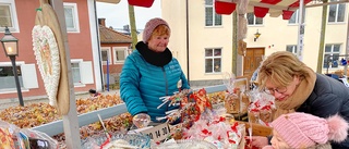 Tätt med tomtar, kransar och besökare på julmarknaden