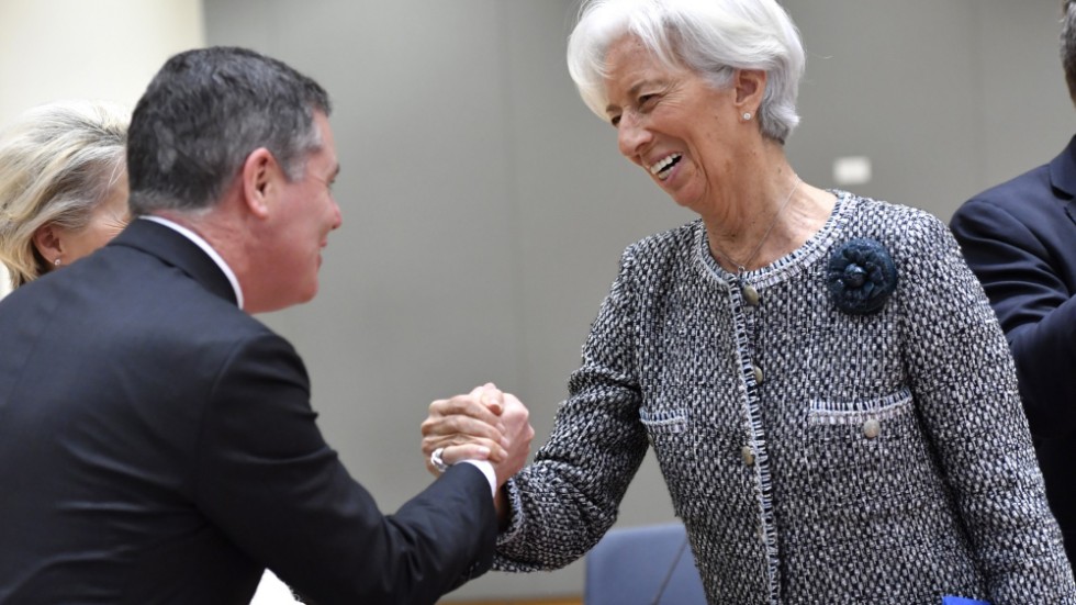 Eurogruppens ordförande Paschal Donohoe och Europeiska centralbankens chef Christine Lagarde skakar hand inne på EU-toppmötet i Bryssel.