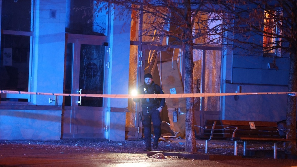 Porten till ett flerbostadshus i Uppsala sprängdes vid bombattentatet. Nu har en 18-åring häktats. 
