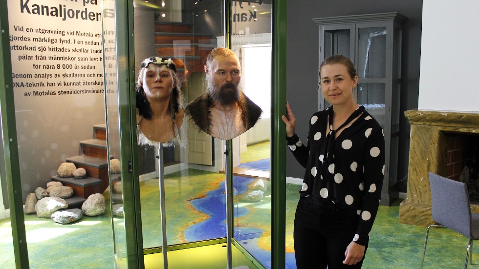 Museiintedent Camilla Gullin med rekonstruerade modeller av stenåldermänniskor. 