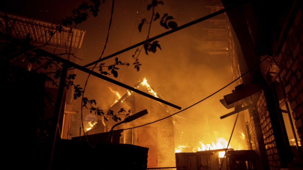 En byggnad i Cherson står i brand efter att ha träffats av rysk eld i lördags.