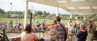 Nyckelharpa och hambo bland häckar och hus