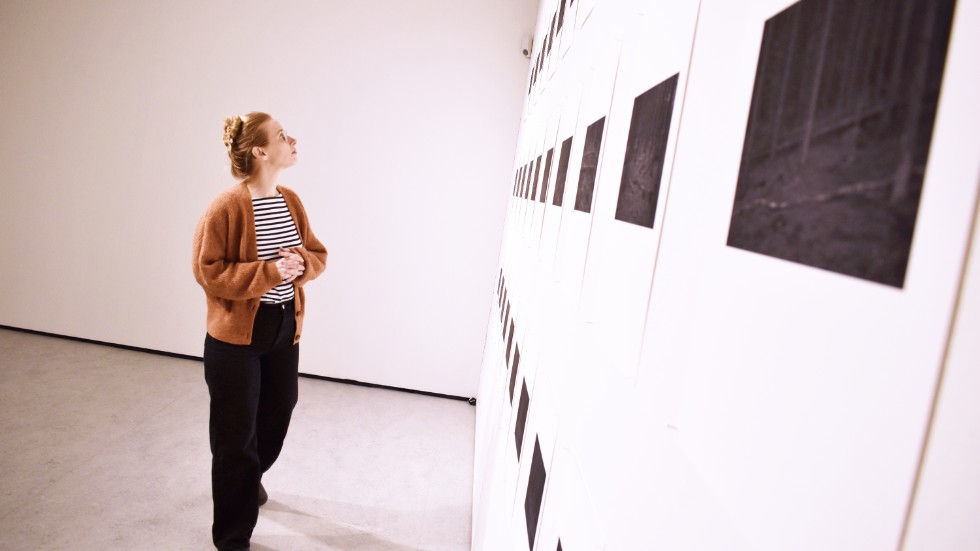 Utställningen heter "Lyssna!" och är frukten av ett samarbete mellan Skellefteå konsthall, konsthallen Färgfabriken och Virserums konsthall. Anna-Karin Larsson står framför Mikael Gudrunssons serie fotografier om skogen. 