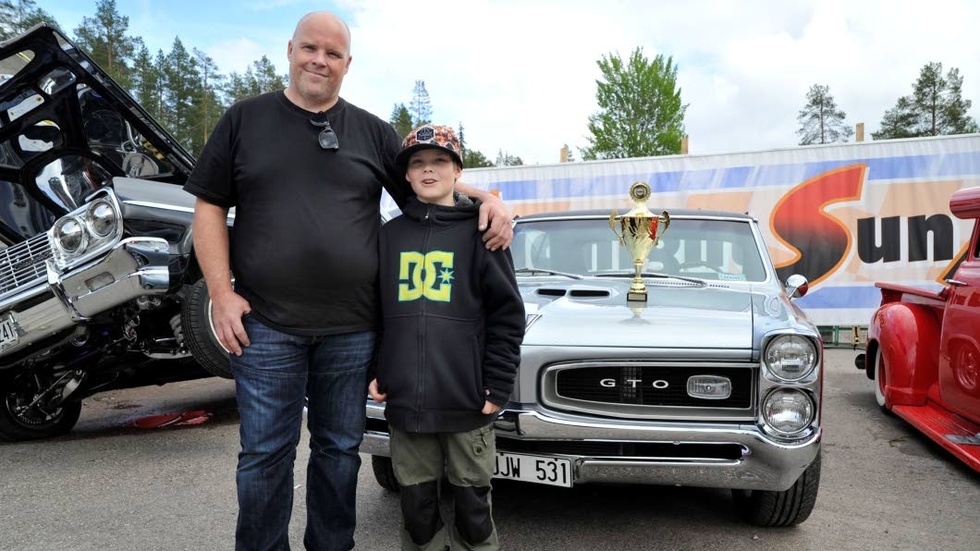 Mikael Broström med sonen Dennis framför deras silvergrå Pontiac GTO från 1966. Tre år har Mikael jobbat med renovering - det resulterade i en fin prisbuckla.