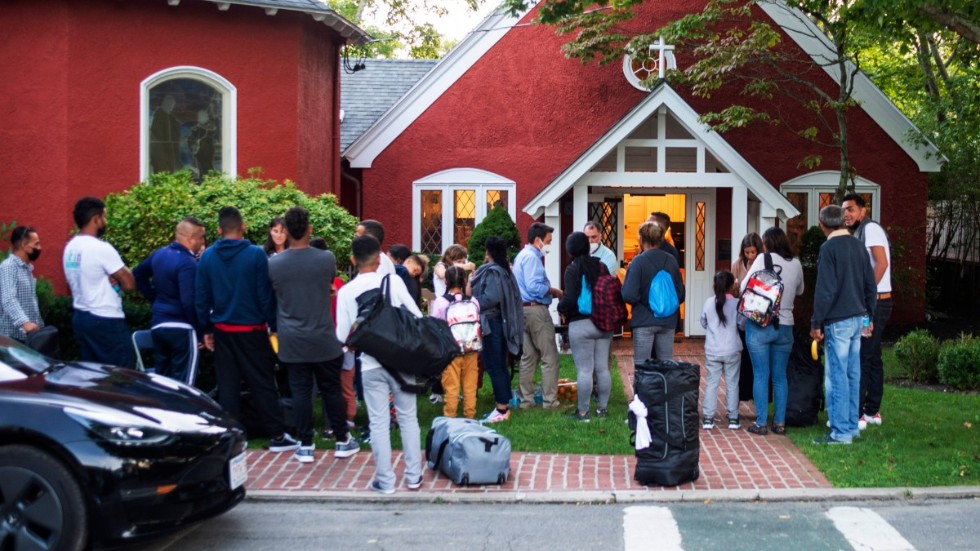 Migranter som flugits från Florida samlas utanför en kyrka på semesterön Martha's Vineyard.