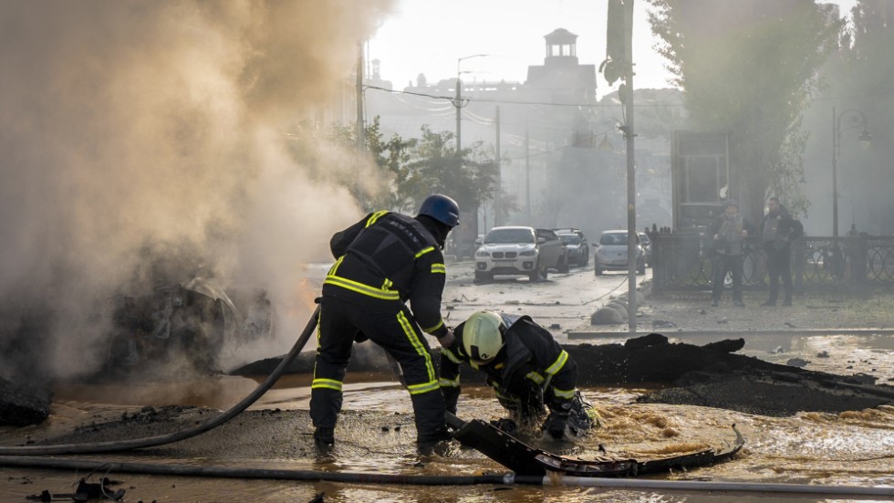 Brandmän i centrala Kiev efter måndagens attacker.