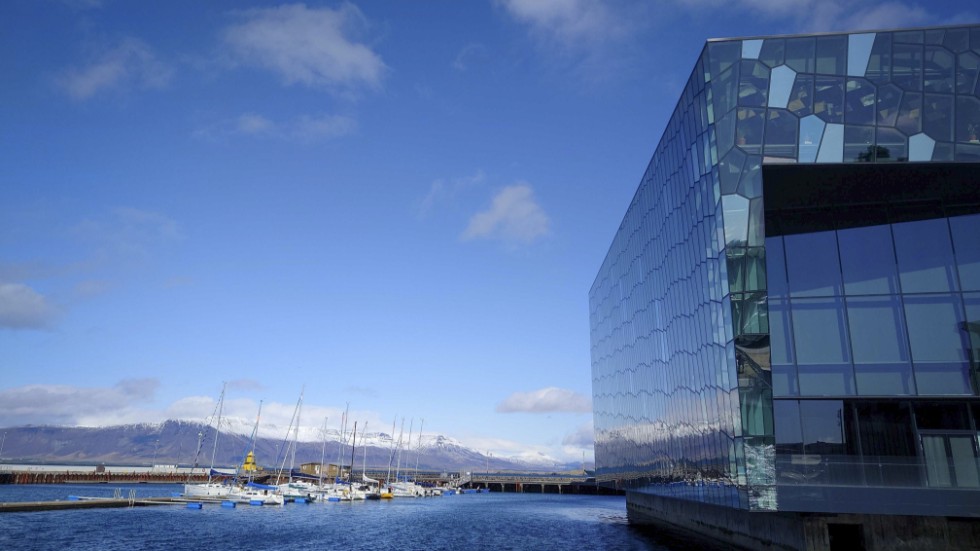 Toppmötesdeltagarna får utsikt över snötäckta fjäll från den pampiga möteslokalen Harpa i centrala Reykjavik.