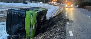 Vägen stängdes av efter buss i diket