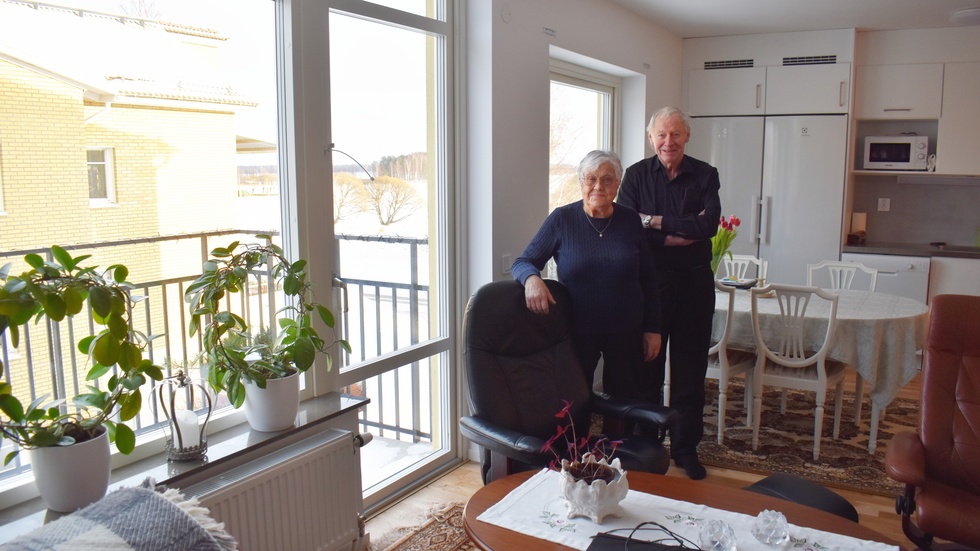 Agneta och Erling Hägglund i det kombinerade köket/vardagsrummet. Vyn genom fönstret är mot sjön. 
