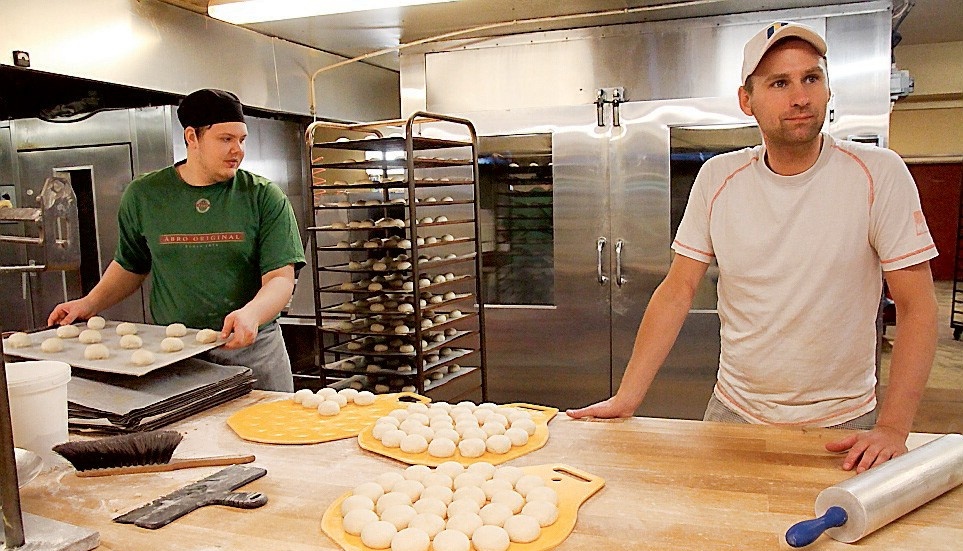 Linus Andersson och Andreas Hugosson hjälps åt att lägga alla bullar på plåtarna innan de ska in i frysen i väntan på jäsugnen.