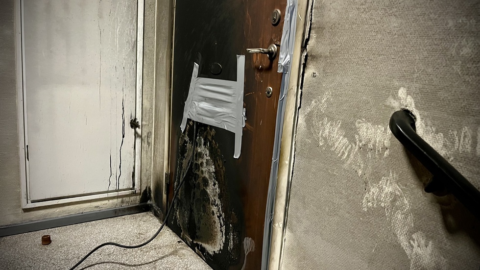 Lägenhetsdörrens utsida fick omfattande skador i samband med branden och en av polisens teorier är att gärningsmännen kastat brandfarlig vätska in genom brevinkastet.