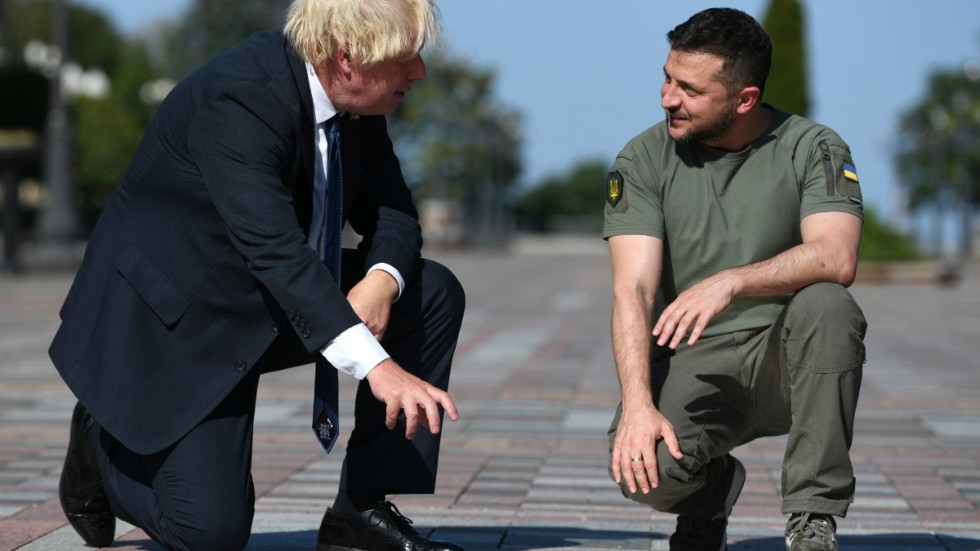 Storbritanniens premiärminister Boris Johnson och Ukrainas president Volodymyr Zelenskyj på plats i Kiev. De tittar på en skylt där personer som hjälpt till i kampen mot den ryska invasionen av Ukraina uppmärksammas.