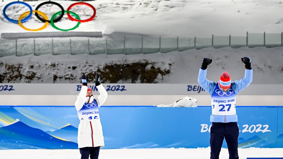 Guldmedaljören Johannes Thingnes Bø (tv) applåderar sin bror och bronsmedaljören Tarjei Bø efter herrarnas sprint.