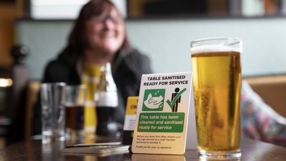 En kvinna tar en öl på en pub i Manchester, England, på måndagen.