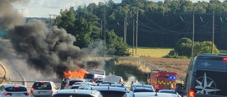 Långa köer på E4:an – bilbrand spred sig till gräset 