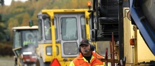 Vägvakten Tommy styr trafiken    med sin röda flagga