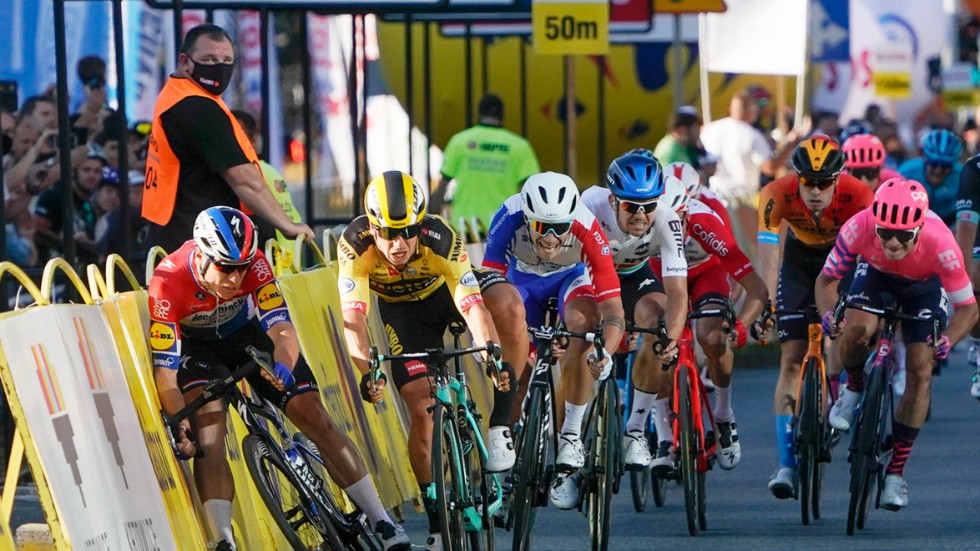 Dylan Groenewegen, i gult, prejar Fabio Jakobsen, till vänster, och orsakar en svår olycka. Nederländaren dödshotades efter kraschen i augusti.