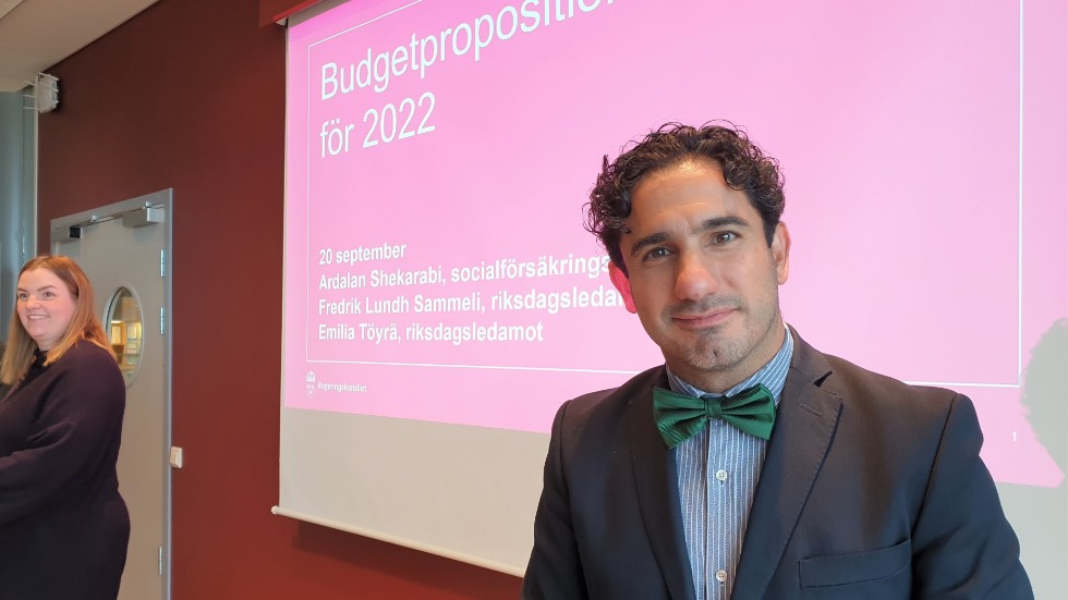 Socialförsäkringsministern, Ardalan Shekarabi, under pressträffen. I bakgrunden skymtar riksdagsledamoten från länet, Emilia Töyrä.
