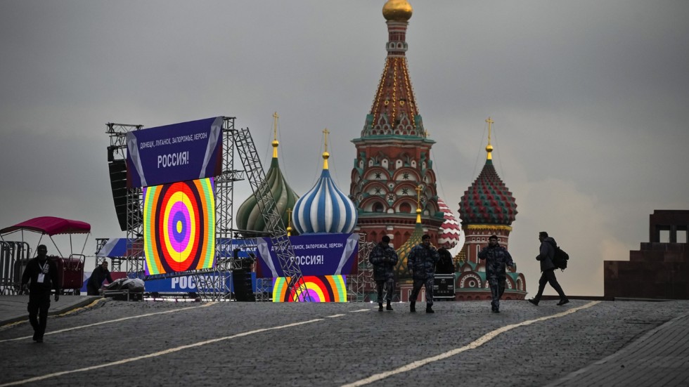 Poliser på Röda torget i Moskva, där det förberetts för en ceremoni. På banderollen som hängts upp står det "Donetsk, Luhansk, Zaporizjzja, Cherson, Ryssland!". Bilden togs i torsdags.