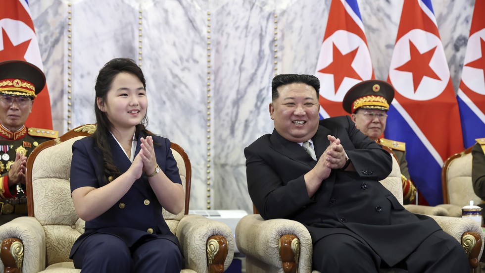 På bilden från nordkoreanska nyhetsbyrån KCNA ses Kim Jong Un och hans dotter, som tros heta Ju Ae, beundra paraden.