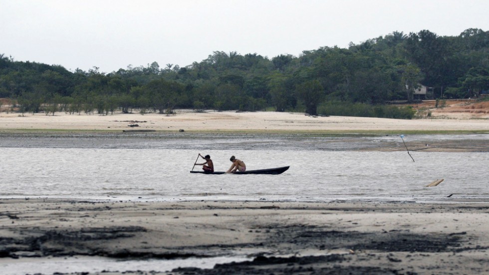 Två personer försöker ta sig fram i en kanot på floden Rio Negro i Manaus. Arkivbild.