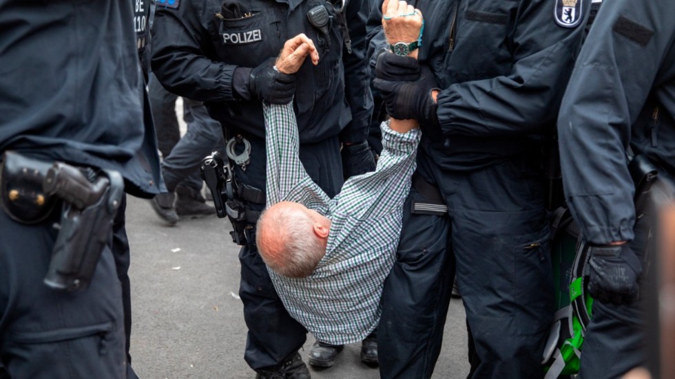 Polisen släpar iväg en man under en demonstration mot covidrestriktioner. Bilden är från en annan protest, i Berlin i fjol.
