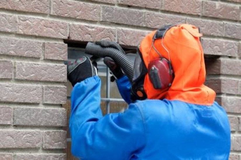 PCB saneras runt ett fönster i en fastighet i Norrköping. Rigorösa förskrifter gör att vartenda millgram tas om hand. Men hur mycket PCB finns det i marken kring husen där regnet lakat ur fogmassorna år ut och år in? Foto: Håkan Sjöström