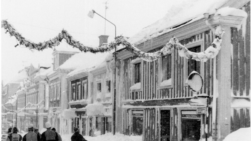 Snöskottning på ett hustak i korsningen Västra Kyrkogatan och Storgatan.