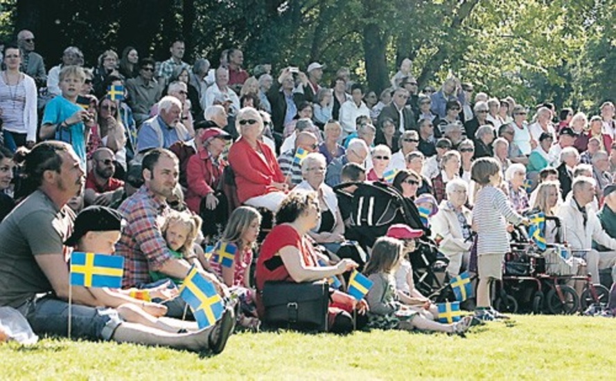 Flaggor, barn och lediga vuxna i Stadsparkens gräs.