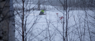 Förare satt fastklämd under skoter i djup snö