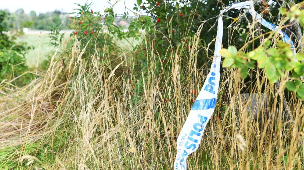 Polisens avspärrningsband vid den åker där en man i 20-årsåldern hittades död i augusti i fjol. Arkivbild.