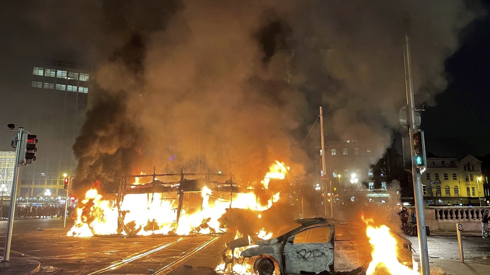 Resterna av en buss och en bil som sattes i brand i Dublin på torsdagen.