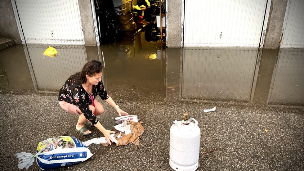 Jenny Bard plockar upp saker som flutit runt i garaget.