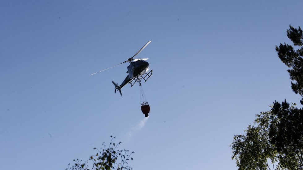 Helikopter som vattenbombar branden i Vrinneviskogen.