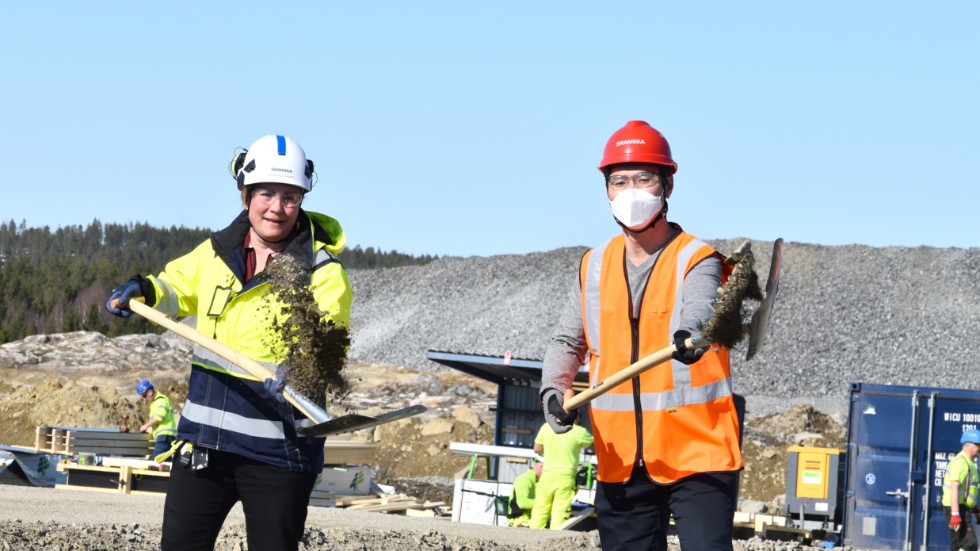 Yun Lee, fabrikschef, Dongjin Sweden (t h), och Linda Hillergren, projektchef, Skanska, tar ett icke formaliserat första spadtag till Dongjins nya fabrik på Skellefteå Site East.