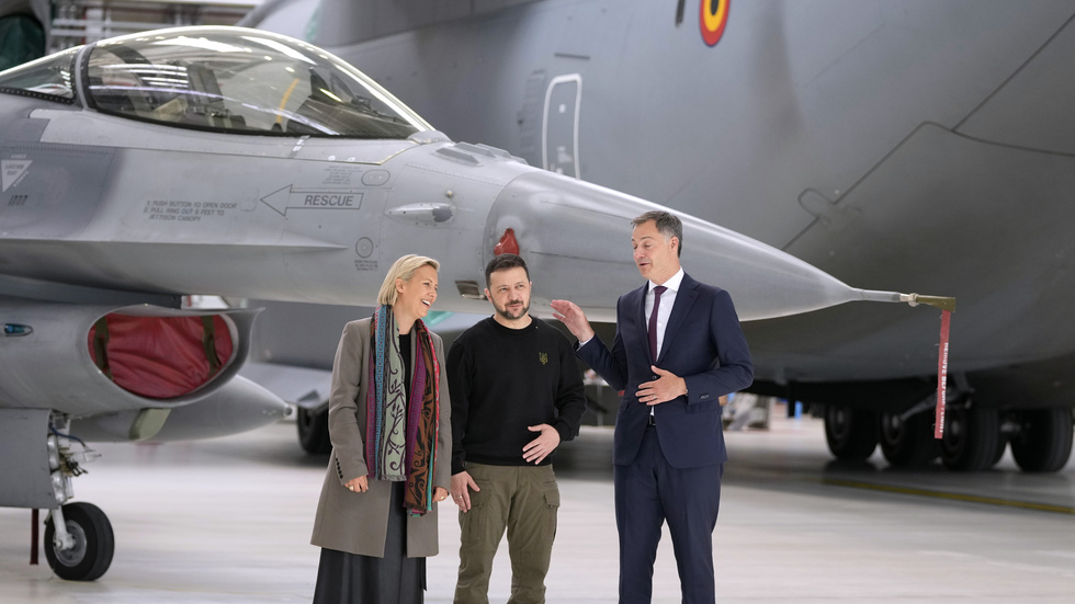 Ukrainas president Volodymyr Zelenskyj tillsammans med Belgiens premiärminister Alexander De Croo och försvarsminister Ludivine Dedonder framför F-16-plan.